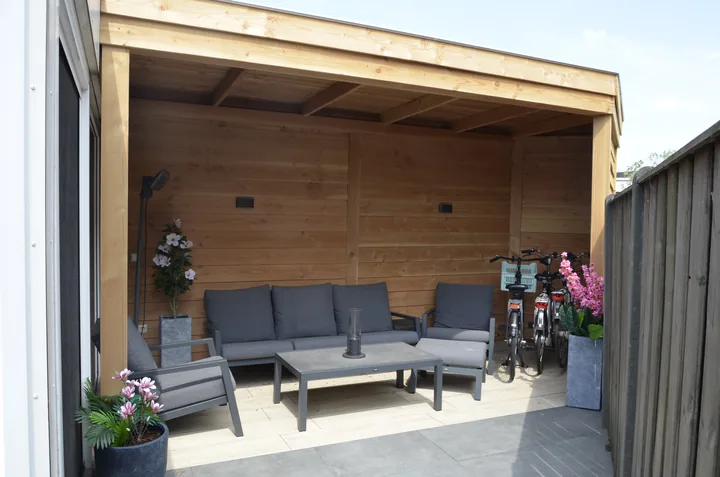 Houten overkapping met loungehoek als maatwerk houtbouw van hovenier J. van Stijn
