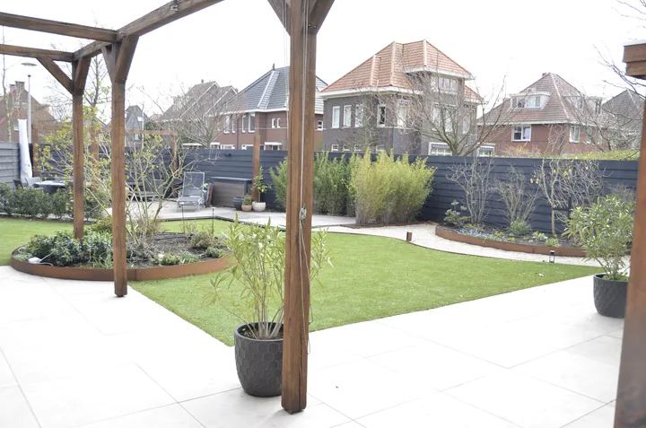 Tuinontwerp met ronde borders, pergola en gazon, ontworpen door hovenier J. van Stijn