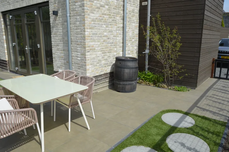 Onderhoudsvriendelijke terrastuin met eethoek en beplanting in Vlaardingen