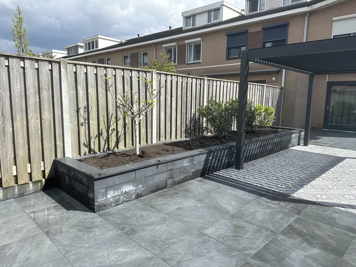 Terrastuin met planters en pergola, aangelegd voor een particuliere opdrachtgever in Bergschenhoek